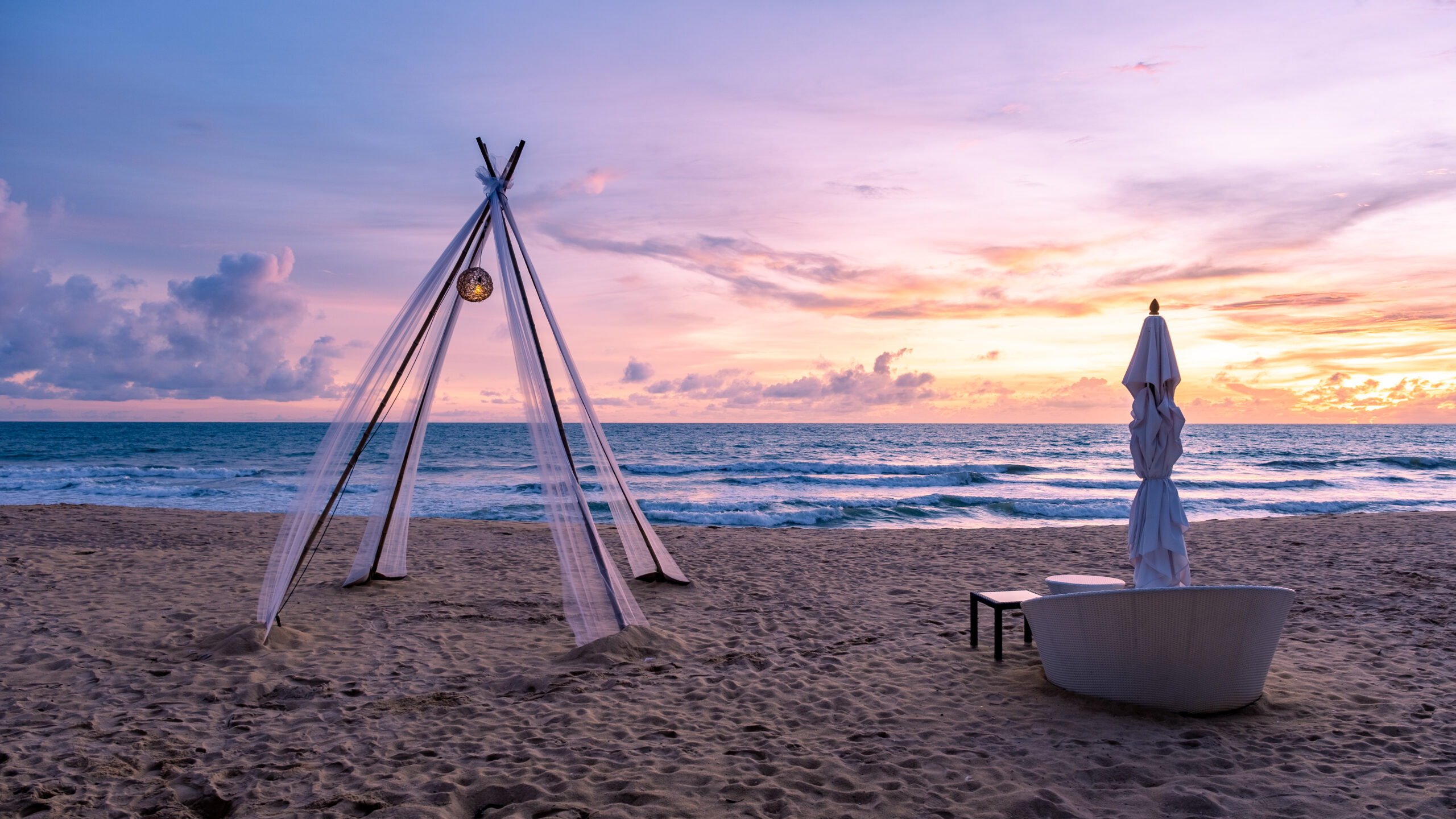 People practicing yoga or meditation on the beach during sunrise